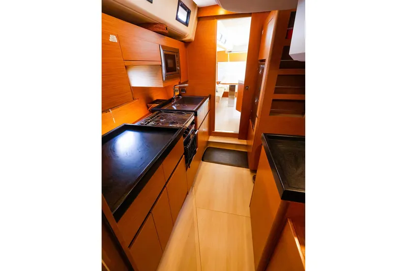 Slide: The Image of Luxurious 2018 Hanse 675 yacht kitchen with modern wood cabinetry and sleek countertops. - 62