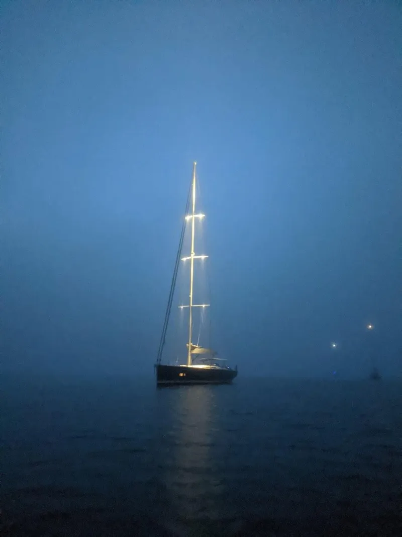 Slide: The Image of Sailing yacht Hanse 675, 2018 model, illuminated at night on calm waters. - 7