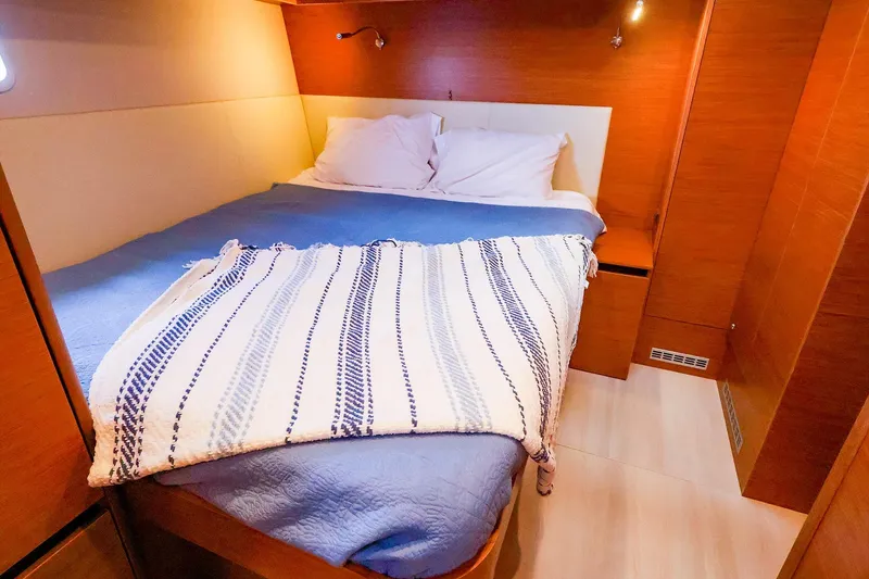 Slide: The Image of Cozy bedroom interior of 2018 Hanse 675 yacht with wooden finish and comfortable bedding. - 70