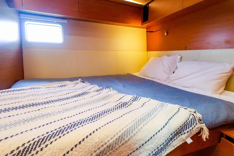 Slide: The Image of Cozy cabin interior of 2018 Hanse 675 yacht with bed and window. - 71