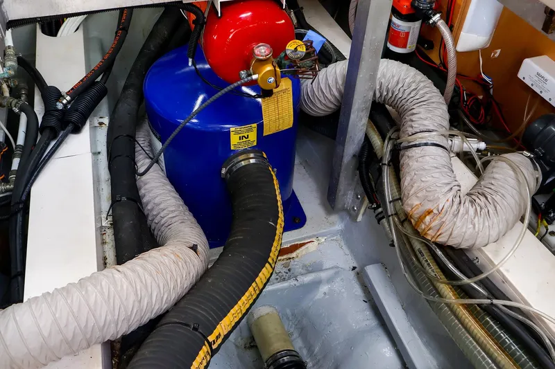 Slide: The Image of Engine room of a 2018 Hanse 675 yacht with hoses and equipment. - 81