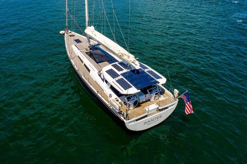 Slide: The Image of 2018 Hanse 675 yacht on open water, featuring solar panels and American flag. - 82