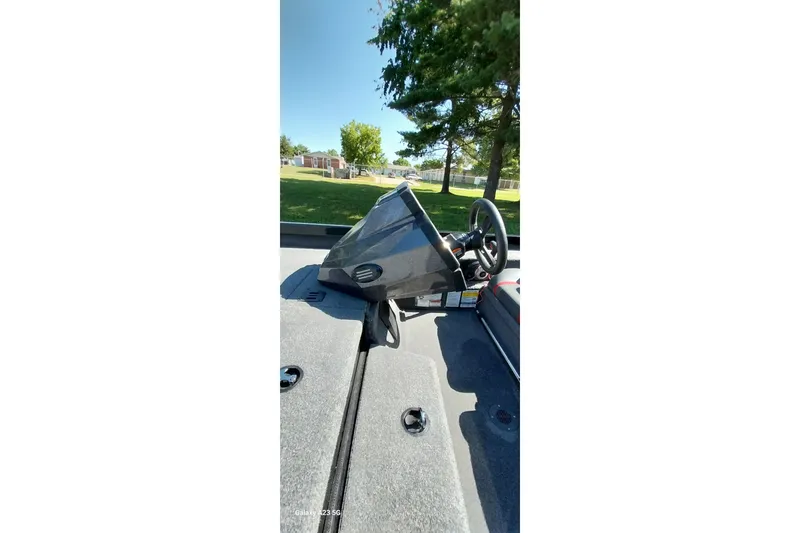 Slide: The Image of 2023 Ranger RT198P boat dashboard with steering wheel, outdoors in a park setting. - 12