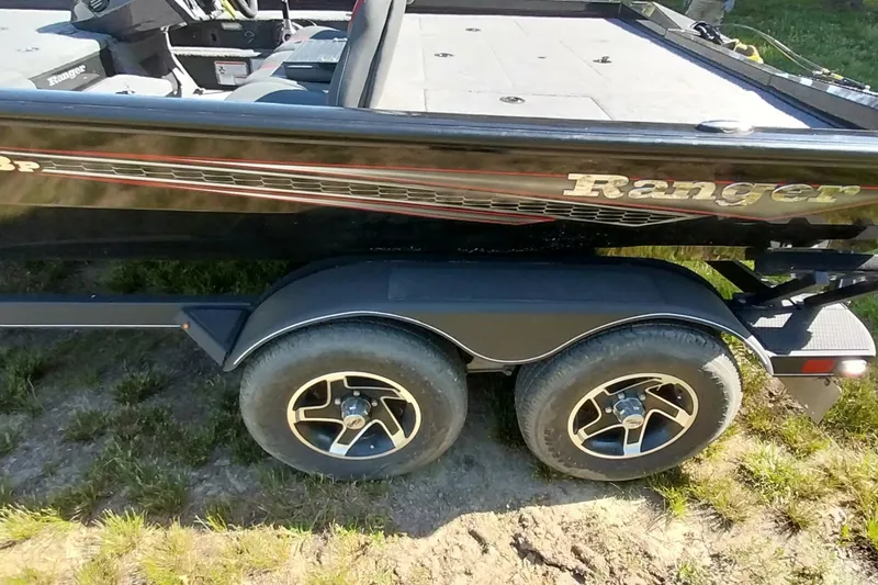 Slide: The Image of 2023 Ranger RT198P boat on trailer, featuring dual wheels and sleek black design. - 21