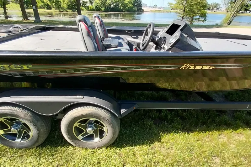 Slide: The Image of 2023 Ranger RT198P boat on trailer by a lake, showcasing sleek design and dual seats. - 24