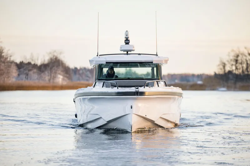 Slide: The Image of 2026 Axopar 38 Cross Cabin boat navigating icy waters, front view. - 10