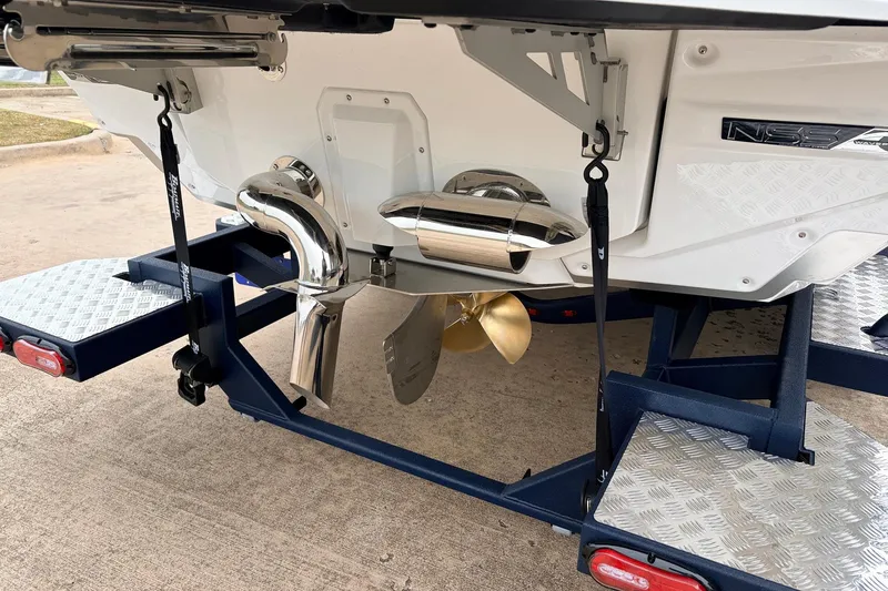 Slide: The Image of 2026 Nautique Super Air Nautique G25 boat on trailer, showcasing propeller and exhaust system. - 10