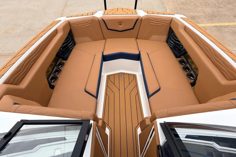 Slide: The Image of 2026 Nautique Super Air Nautique G25 boat interior with tan seating and cup holders. - 17