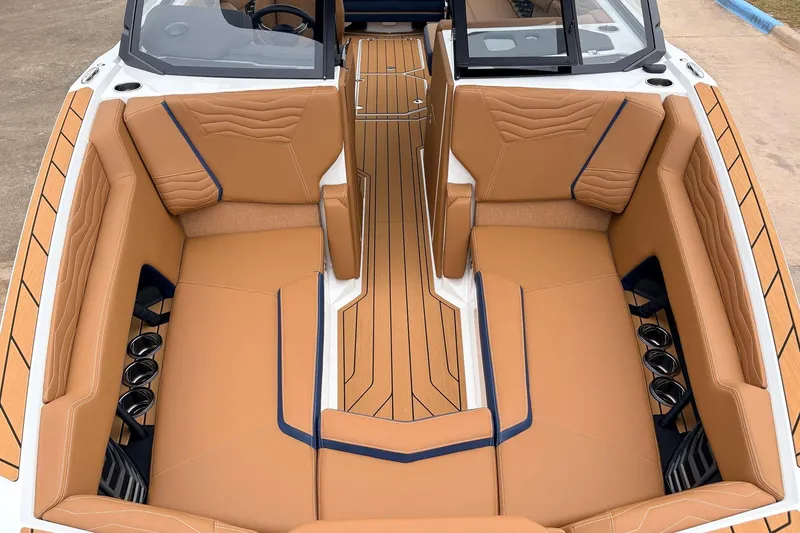 Slide: The Image of 2026 Nautique Super Air Nautique G25 interior with tan leather seating and cup holders. - 20