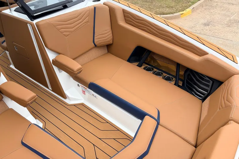 Slide: The Image of Luxurious interior of 2026 Nautique Super Air Nautique G25 with tan upholstery and cup holders. - 22