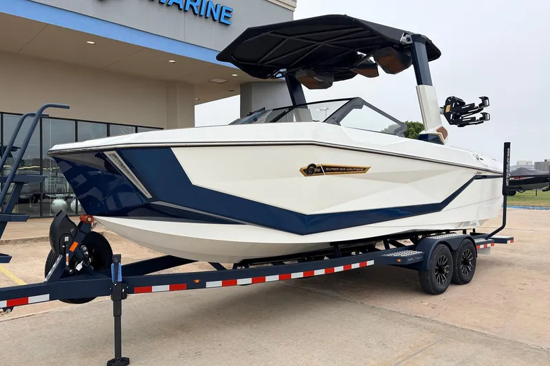 Slide: The Image of 2026 Nautique Super Air Nautique G25 boat on trailer, displayed outside a marine dealership. - 3