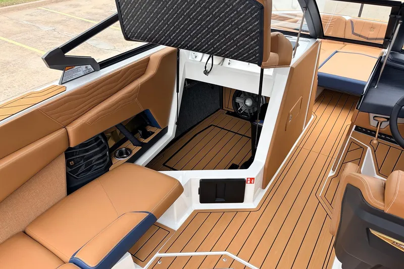 Slide: The Image of 2026 Nautique Super Air Nautique G25 interior with tan seating and wood-style flooring. - 33