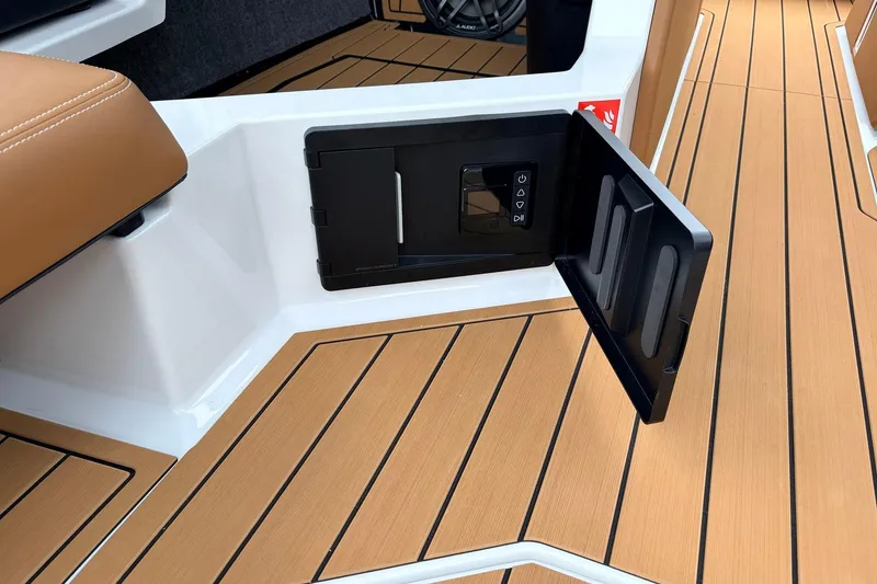 Slide: The Image of 2026 Nautique Super Air Nautique G25 interior with open storage compartment and teak flooring. - 37
