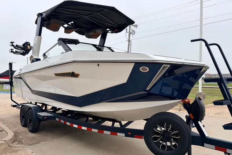Slide: The Image of 2026 Nautique Super Air Nautique G25 boat on trailer, sleek design, white and blue color. - 4