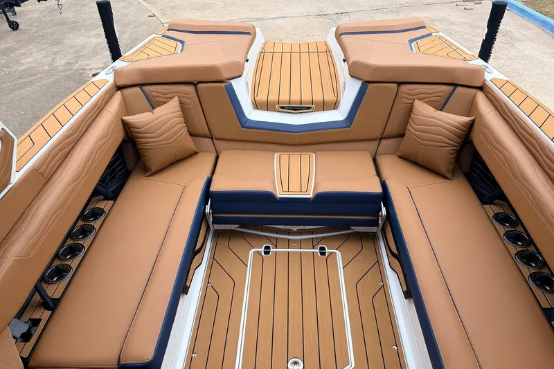 Slide: The Image of 2026 Nautique Super Air Nautique G25 interior with luxurious tan seating and cup holders. - 43