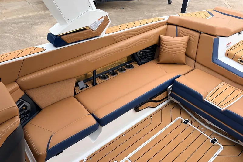 Slide: The Image of Luxurious interior of 2026 Nautique Super Air Nautique G25 with tan seating and cup holders. - 49
