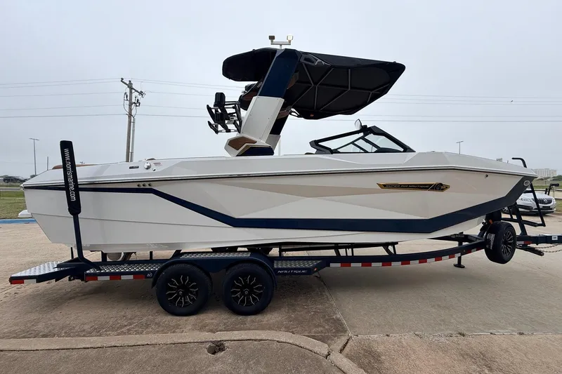 Slide: The Image of 2026 Nautique Super Air Nautique G25 boat on trailer, side view. - 5