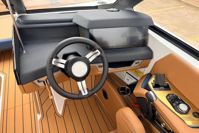 Slide: The Image of Interior of 2026 Nautique Super Air Nautique G25 boat, featuring sleek steering and controls. - 57