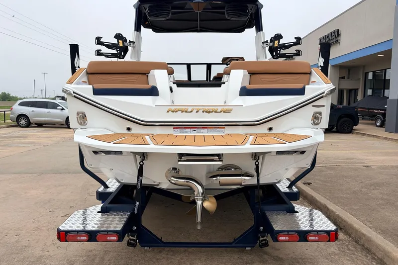 Slide: The Image of 2026 Nautique Super Air Nautique G25 boat rear view in a parking lot. - 7
