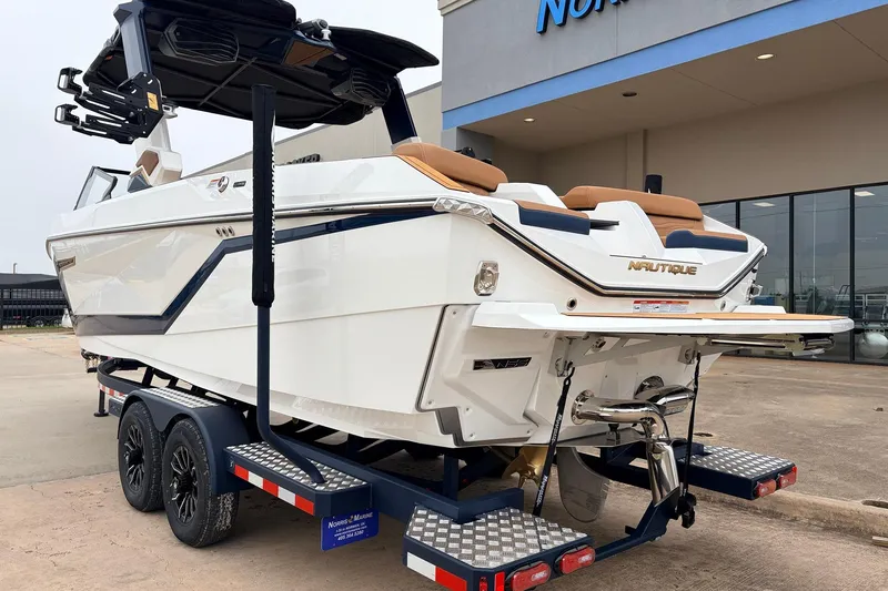 Slide: The Image of 2026 Nautique Super Air Nautique G25 boat on trailer outside dealership. - 8