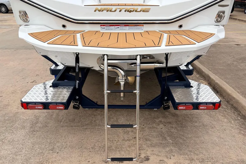 Slide: The Image of 2026 Nautique Super Air Nautique G25 boat rear view with swim platform and ladder. - 9