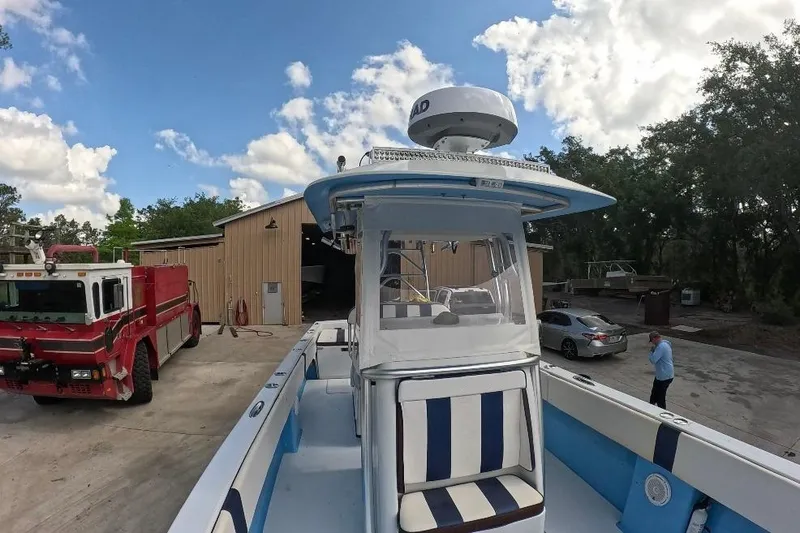Slide: The Image of 2018 Catamaran Coaches 38 Lightning boat docked near a garage, with a fire truck nearby. - 21
