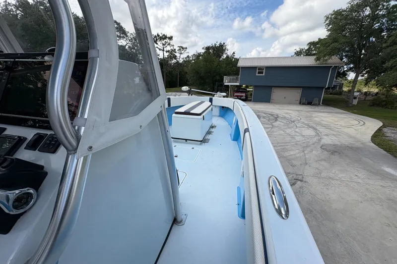 Slide: The Image of 2018 Catamaran Coaches 38 Lightning boat docked near a blue house under a cloudy sky. - 28