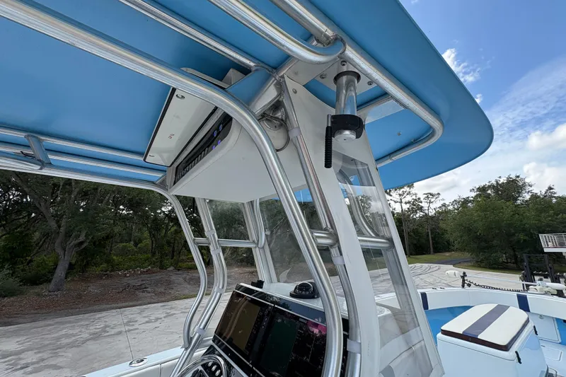 Slide: The Image of 2018 Catamaran Coaches 38 Lightning boat with blue canopy and modern dashboard. - 36