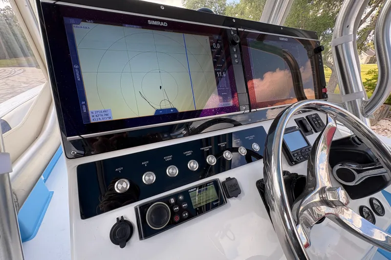 Slide: The Image of Control panel of a 2018 Catamaran Coaches 38 Lightning with navigation screens and steering wheel. - 38