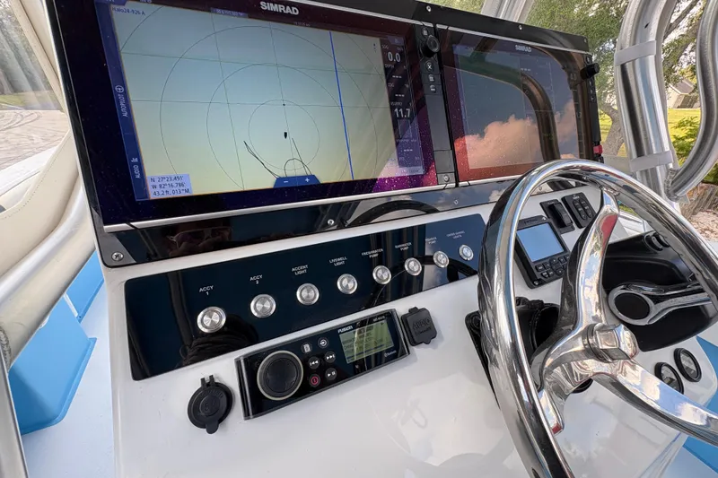 Slide: The Image of Control panel of a 2018 Catamaran Coaches 38 Lightning with navigation screens and steering wheel. - 39
