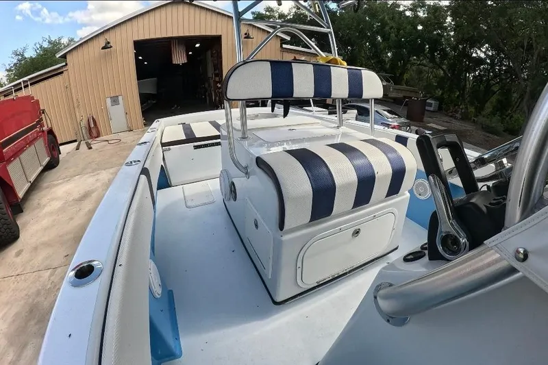 Slide: The Image of 2018 Catamaran Coaches 38 Lightning boat with striped seating, parked near a garage. - 40