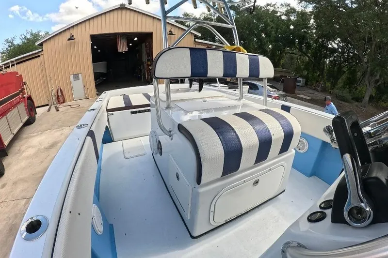 Slide: The Image of 2018 Catamaran Coaches 38 Lightning boat with striped seating, parked near a garage. - 41