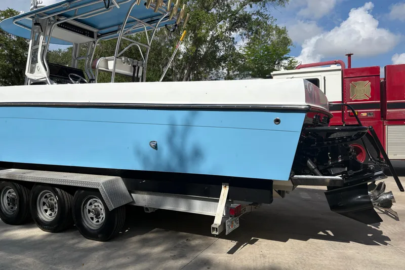Slide: The Image of 2018 Catamaran Coaches 38 Lightning boat on trailer, blue hull, parked outdoors. - 6