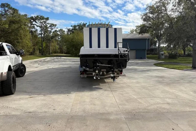 Slide: The Image of 2018 Catamaran Coaches Lightning Powerboats on trailer, parked outdoors under a partly cloudy sky. - 4