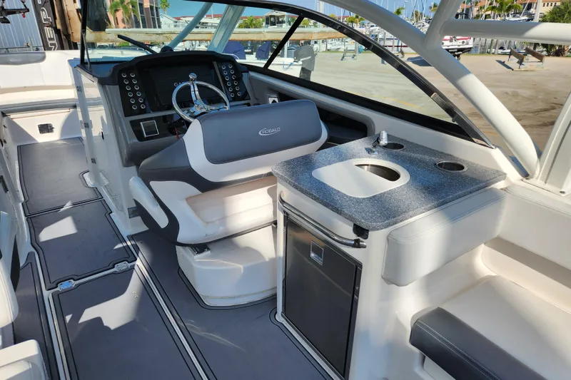 Slide: The Image of 2019 Robalo R317 Dual Console boat interior with helm, seating, and kitchenette. - 11