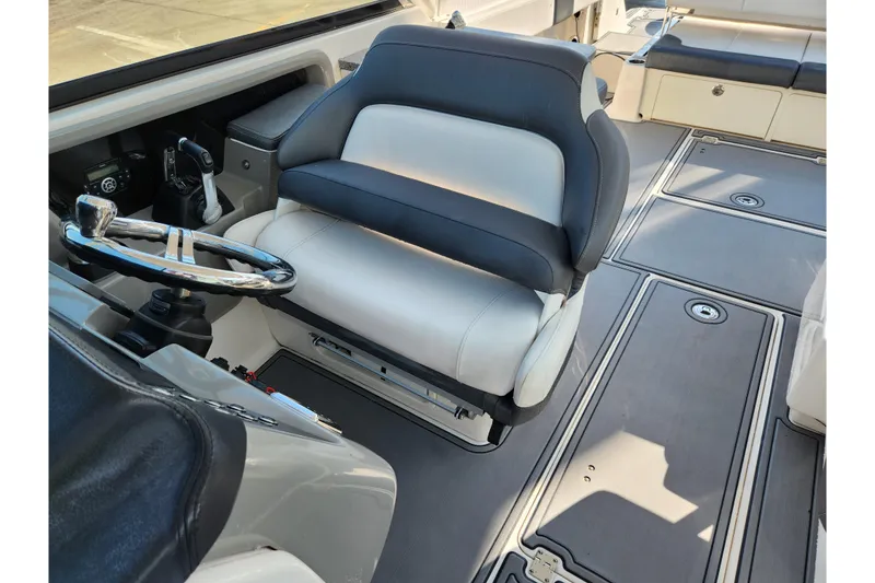 Slide: The Image of 2019 Robalo R317 Dual Console helm with cushioned captain's chair and steering wheel. - 21