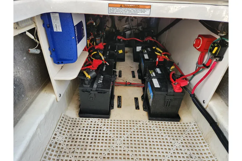 Slide: The Image of 2019 Robalo R317 Dual Console boat battery compartment with multiple batteries and wiring. - 26