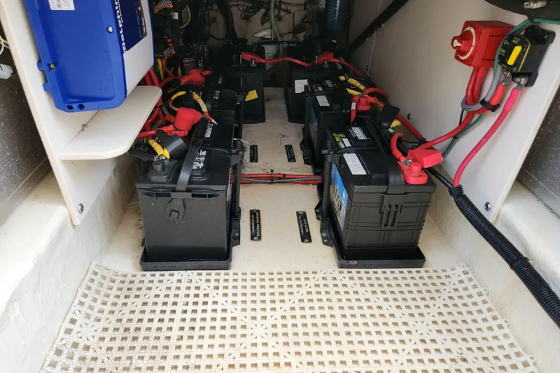 Slide: The Image of Battery compartment of a 2019 Robalo R317 Dual Console boat, featuring multiple batteries and wiring. - 30