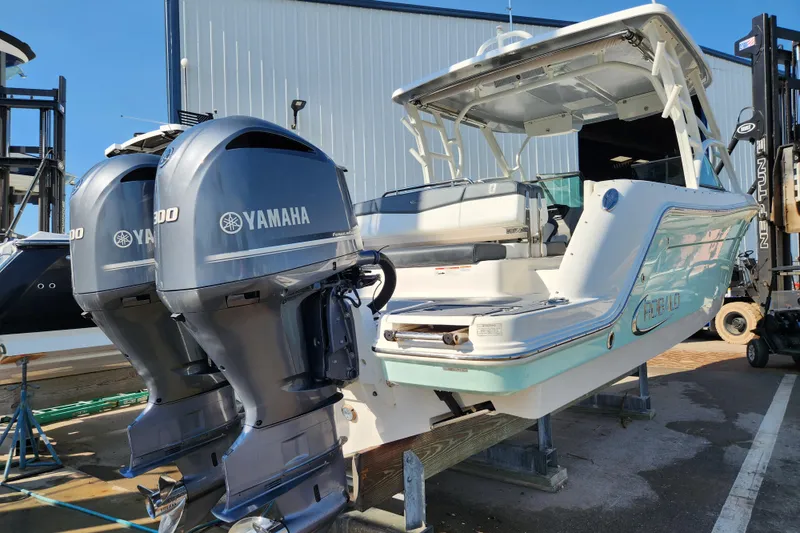 Slide: The Image of 2019 Robalo R317 Dual Console boat with twin Yamaha engines, docked outdoors. - 4