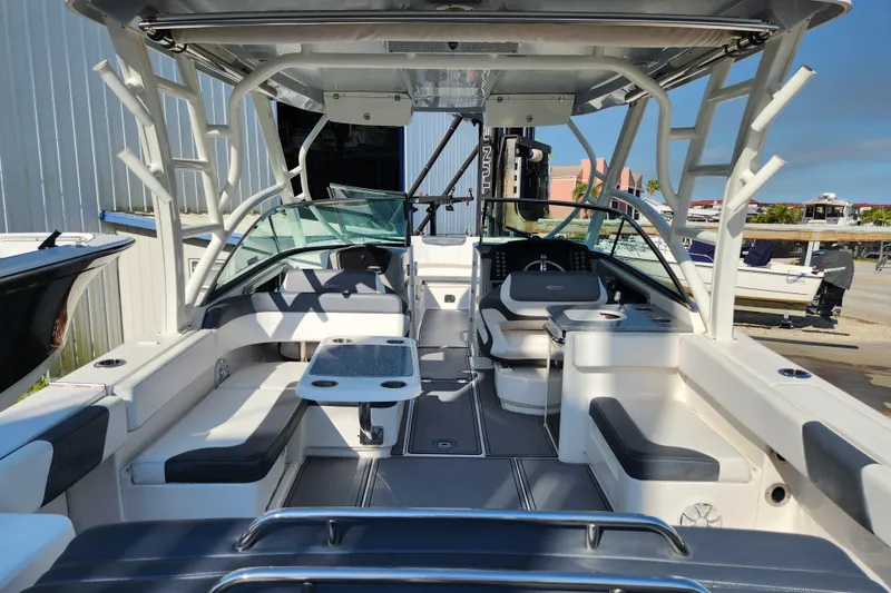 Slide: The Image of 2019 Robalo R317 Dual Console boat interior with seating and table, docked outdoors. - 5