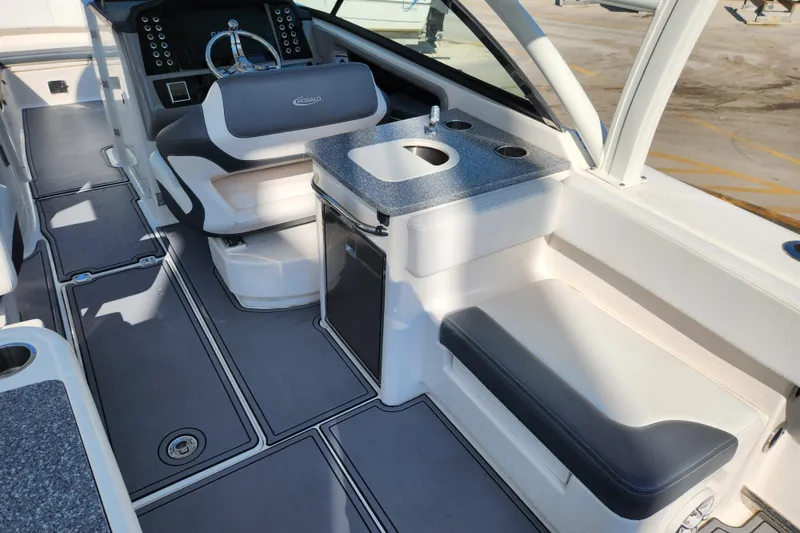 Slide: The Image of 2019 Robalo R317 Dual Console boat interior with helm, seating, and sink area. - 6