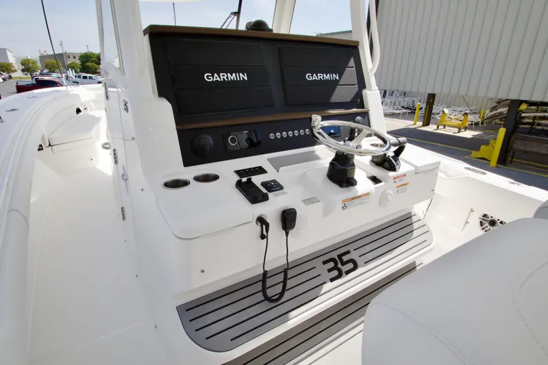 Slide: The Image of 2026 Regulator 35 boat helm with Garmin navigation systems and steering wheel. - 11