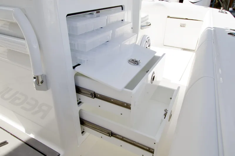 Slide: The Image of Storage compartments on a 2026 Regulator 35 boat, featuring organized drawers and tackle boxes. - 15