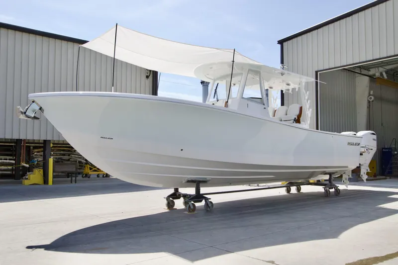 Slide: The Image of 2026 Regulator 35 boat with canopy, parked outside a warehouse. - 29