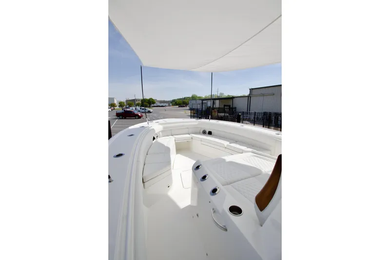 Slide: The Image of 2026 Regulator 35 boat interior with white seating and canopy in a parking lot. - 8