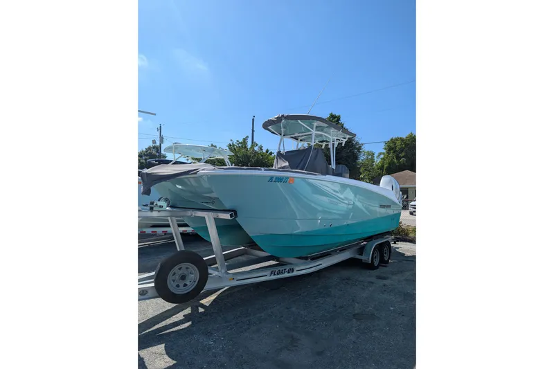 The Image of 2024 Twin Vee 240 GFX CC boat on trailer under clear blue sky. - 0