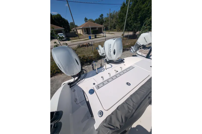 Slide: The Image of 2024 Twin Vee 240 GFX CC boat with Suzuki outboard motors, parked outdoors. - 11