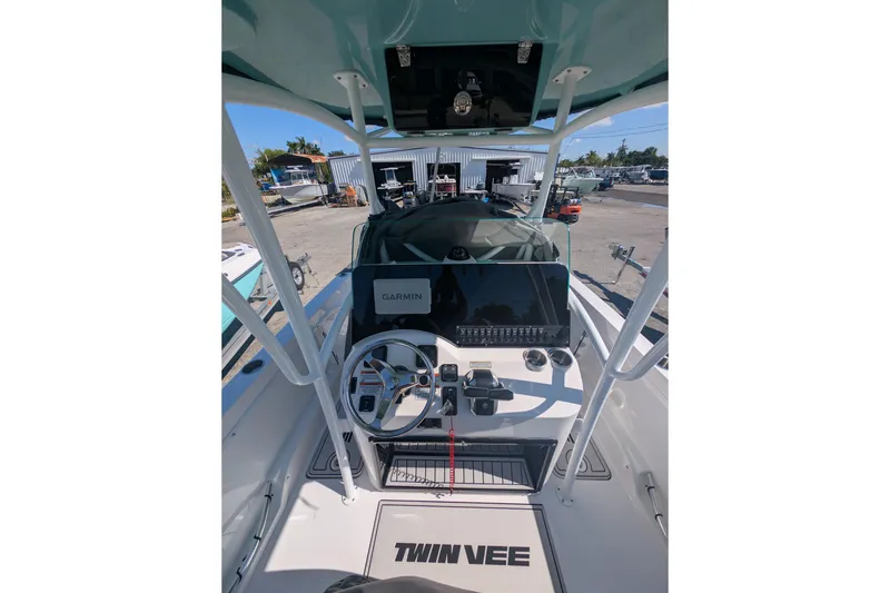 Slide: The Image of 2024 Twin Vee 240 GFX CC boat console with Garmin navigation system and steering wheel. - 2