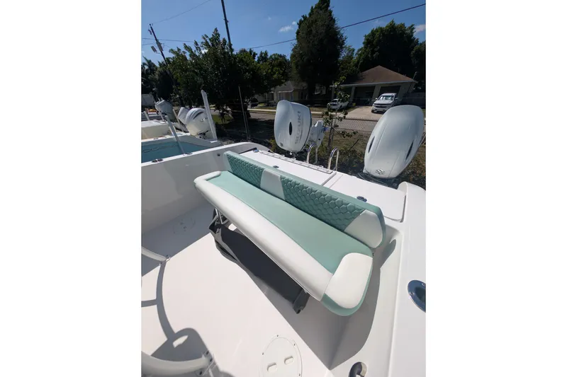 Slide: The Image of 2024 Twin Vee 240 GFX CC boat interior with cushioned seating and dual outboard motors. - 7