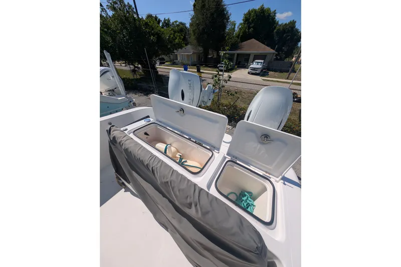 Slide: The Image of 2024 Twin Vee 240 GFX CC boat with open storage compartments and visible outboard motors. - 8